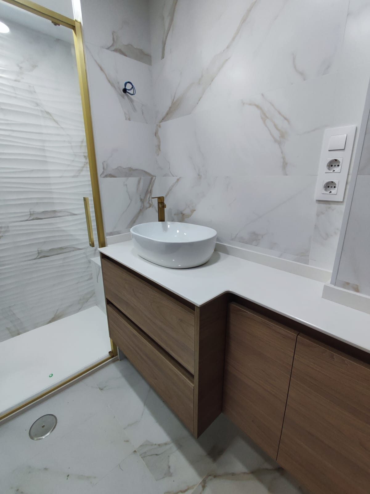 Baño con mueble de madera y detalles dorados