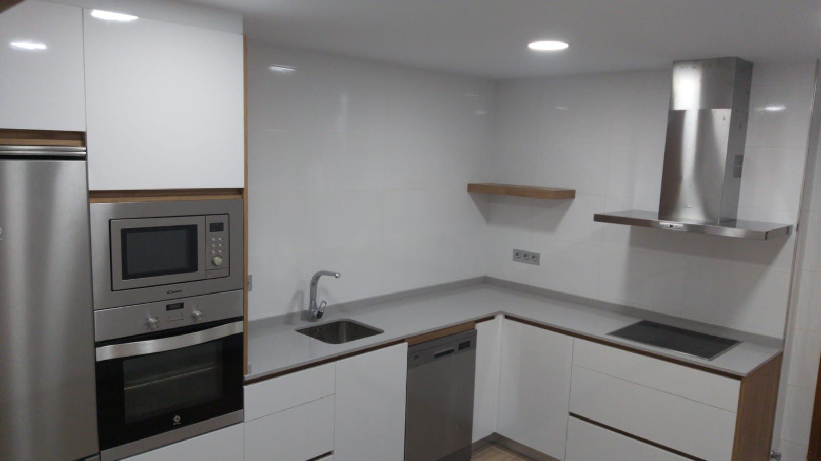 Cocina blanca reformada con campana y electrodomésticos